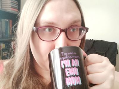 Photo of the author drinking from a coffee mug with stylized text reading 'I'm not a regular mom, I'm an emo mom.'